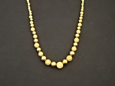 un collier de perles dorées sur fond noir