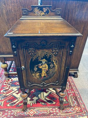 une vieille armoire en bois ornée d'un tableau sur la façade
