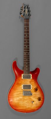 une guitare électrique avec un corps en bois et une face supérieure rouge