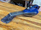 un aspirateur à fil bleu et noir posé sur une table en bois