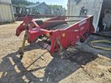une photo d'une machine agricole rouge dans une cour