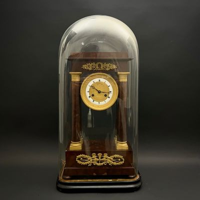 a clock under a glass dome on a black background