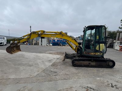 a picture of a small excavator parked in a parking lot