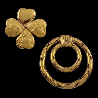 two pieces of gold jewelry on a black background