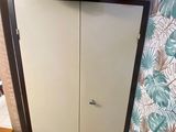 a cat that is sitting on the floor next to a cabinet
