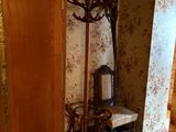 a coat rack in the corner of a room next to a chair