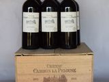 trois bouteilles de vin rouge dans un coffret en bois sur une table