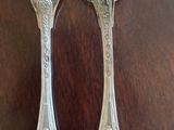 two spoons and a fork sitting on a table