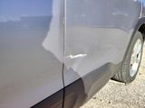 a close up of a car ' s side door with a hole in it