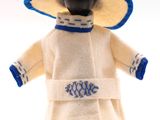 une poupée qui porte un chapeau et un manteau
