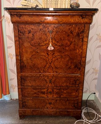 a wooden chest of drawers with a clock on top of it