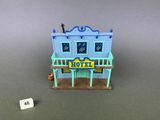 un gros plan d'un bâtiment miniature sur lequel est accrochée une pancarte