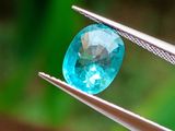 un gros plan d'un diamant bleu tenu par une pince