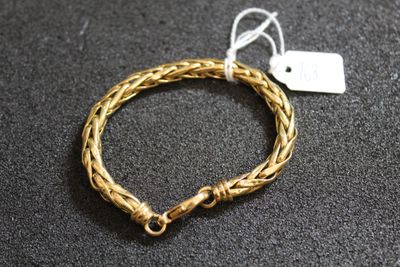 Gros plan sur un bracelet en or portant une étiquette