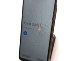 a broken glass screen on the back of a cell phone