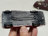 a person holding a toy car in their hand next to a toy car