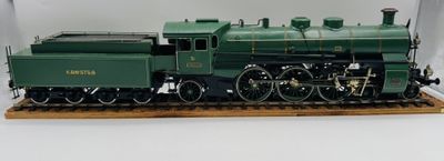 une maquette de train vert posée sur un socle en bois