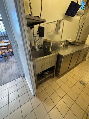 a kitchen with a sink and a television mounted on the wall