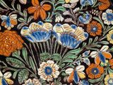 a black plate with colorful flowers and leaves on it