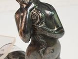 une statue représentant une femme assise à l'avant d'un bateau
