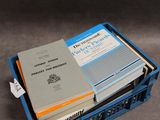 de nombreux livres dans une caisse bleue posée sur la table
