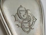 a silver spoon with a design on it sitting on a table