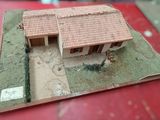 a small model of a house on a red table