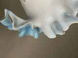 a white and blue vase with a bird on it