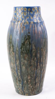 un vase bleu posé sur une surface blanche