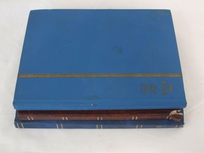 deux livres bleus posés l'un sur l'autre sur une surface blanche