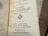 un vieux livre posé sur une table recouverte de papiers