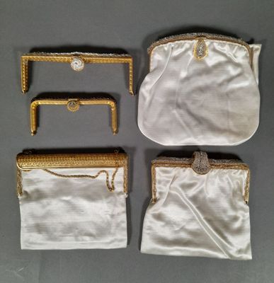 three white purses with gold trims and chains on them
