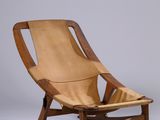une photo d'un fauteuil à bascule en bois avec une assise en cuir beige