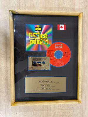 une photo encadrée représentant un CD et une cassette, dans un cadre en bois