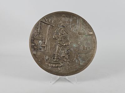 une vieille assiette en argent sur laquelle est représenté un homme et une femme