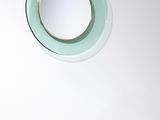 un miroir rond accroché au mur au-dessus d'un lavabo