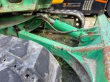 a close up of a green tractor with a big tire