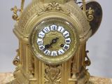 a gold clock with roman numerals on it