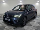 a grey car is parked on a checkered floor in a garage