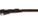 un fusil avec un canon en bois sur fond blanc