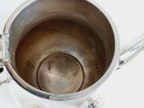 a silver cup with a spoon in it on a table