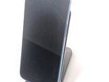 a broken cell phone sitting on top of a stand