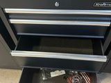 une photo d'une armoire à outils noire avec des tiroirs