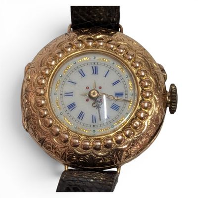 a gold watch with roman numerals on the face