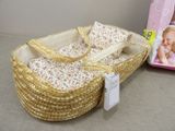 a basket with a baby in it next to a pink box