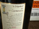 a bottle of wine sitting on a table next to a package of liquor