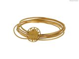 gros plan d'un bracelet en or sur fond blanc