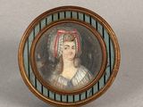 an old picture of a woman with a red headband in a gold frame