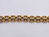 a close up of a gold bracelet on a white surface