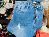 a cardboard box full of clothes and a pair of jeans